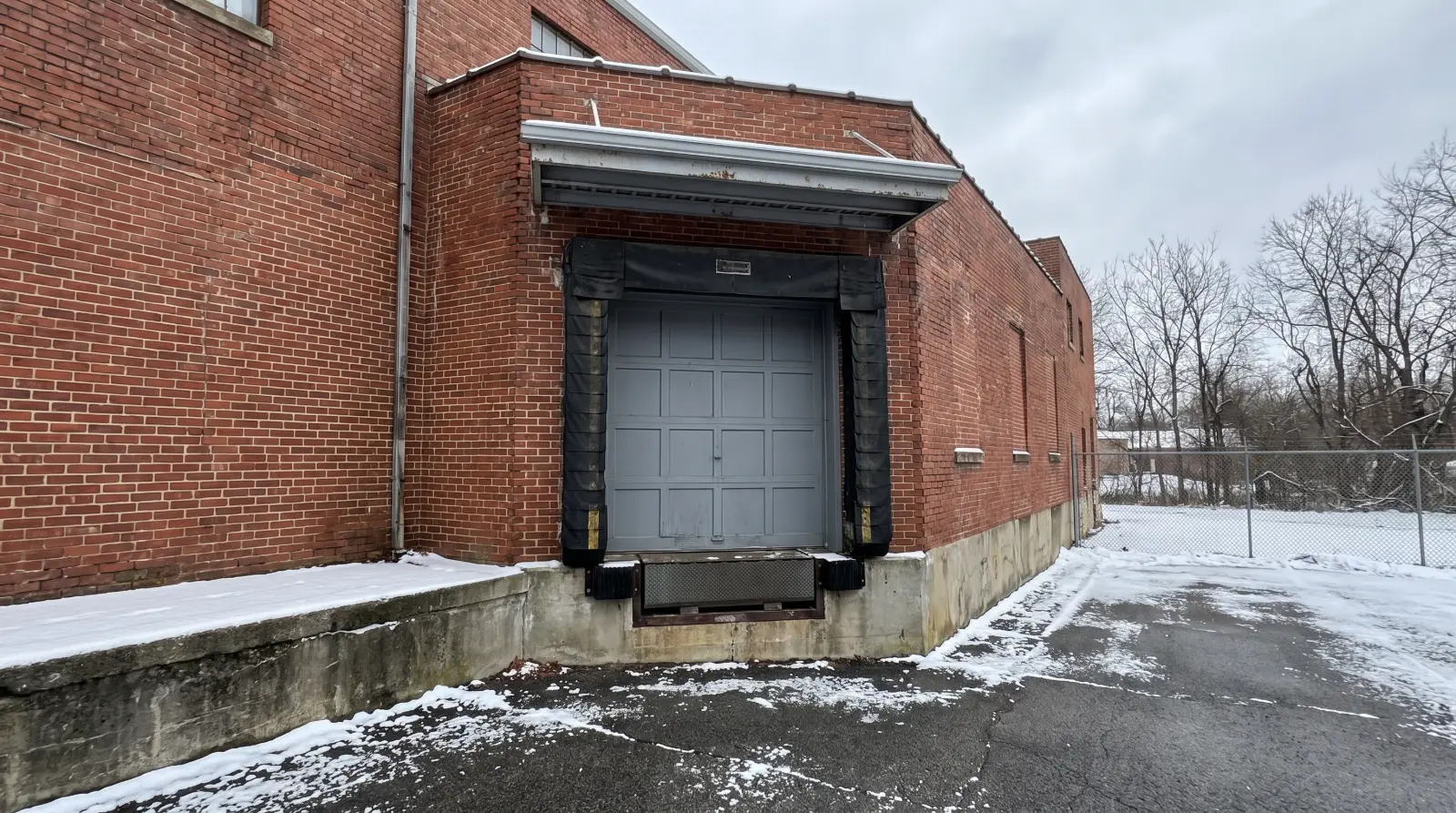 Loading dock door with a compressed dock seal around a trailer